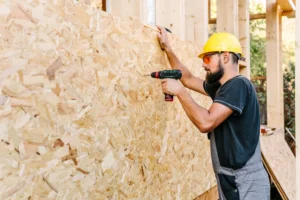 Um profissional montando uma casa pré-fabricada de madeira
